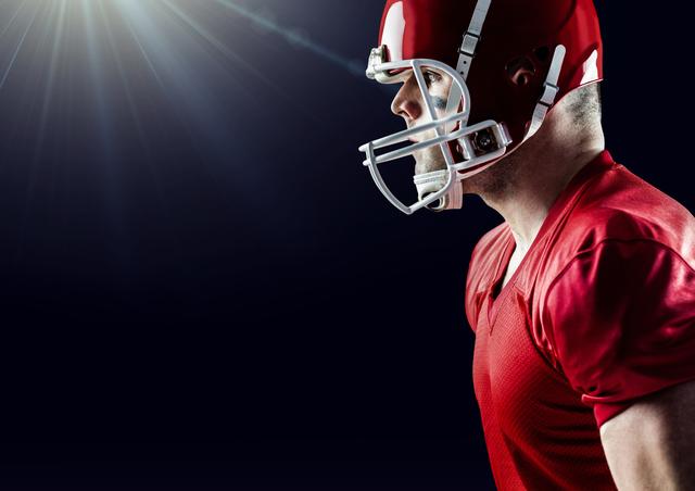 This image captures a side view of an American football player wearing a red uniform and helmet, highlighting his focus and determination. Ideal for use in sports-related content, advertisements, team promotions, and articles about football or athleticism.