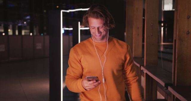 Man Enjoying Music on Smartphone During Night Walk - Download Free Stock Images Pikwizard.com