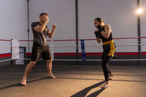 Barefoot Boxing Sparring Session with Hand Wraps and Dramatic Gym Lighting