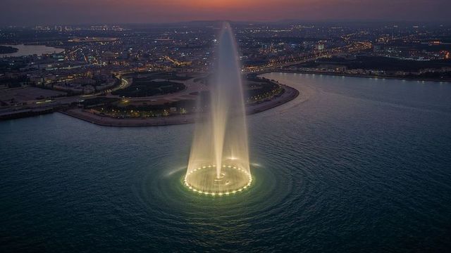 Illuminated waterfront fountain at night
