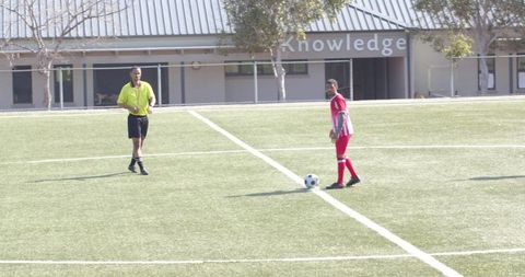 Soccer referee and player strategizing on field before match