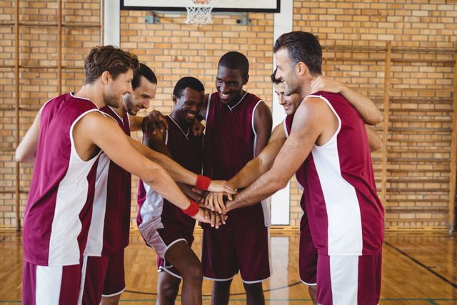 Team of basketball players stacking hands in the court