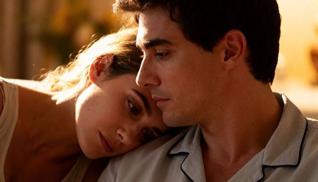 Couple leaning close in warm golden glow resting together in tender evening embrace