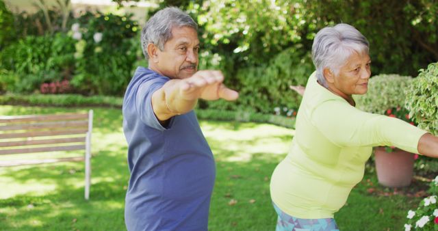 Image of relaxed biracial senior couple practicing yoga in garden. active retirement lifestyle, senior relationship and exercising concept.