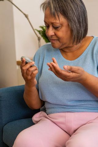 Senior Woman Checking Glucose Levels at Home