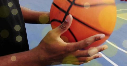 Basketball player gripping ball on indoor court