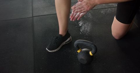 Athlete applying chalk near kettlebell for intense workout