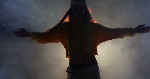 Dynamic dancer posing with dramatic lighting and fog