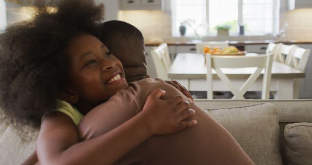 African american daughter and her father smiling and hugging on couch - Download Free Stock Photos Pikwizard.com