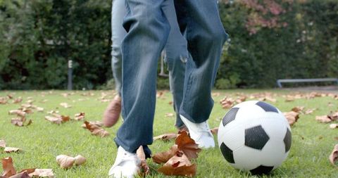 Mother and son enjoying soccer in autumn garden