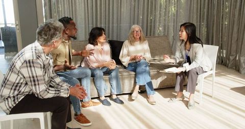 Group therapy session with diverse patients and therapist