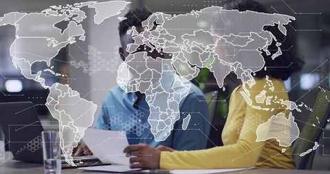 Business team analyzing global data on laptop with world map overlay for collaboration