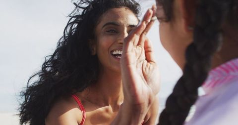 Happy Mother Applying Suncream to Daughter on Day Beach Trip