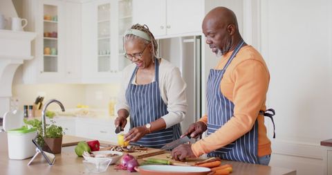 Senior Couple Joyfully Preparing Vegetables in Bright Kitchen - Download Free Stock Images Pikwizard.com