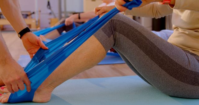 A physical therapist aids a woman's lower body recovery using a resistance band. - Download Free Stock Photos Pikwizard.com