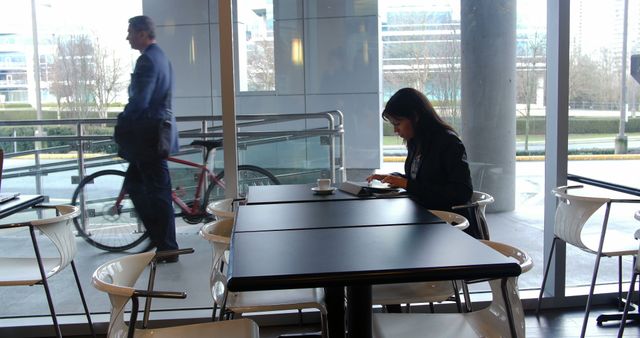 Woman Working Alone at Cafe with Businessman Walking Past Window - Download Free Stock Images Pikwizard.com