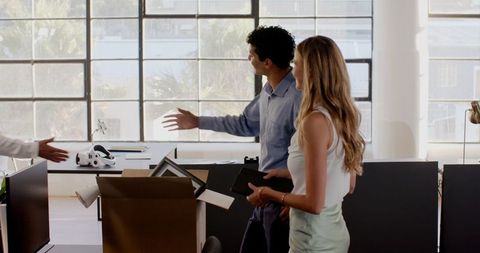 Colleagues collaborating in modern office unpacking