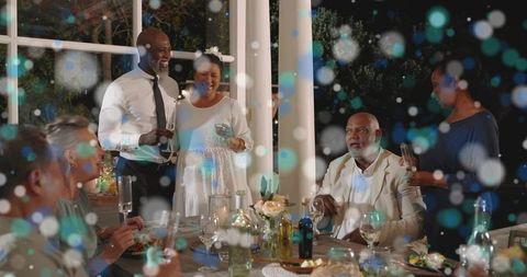 Porch dinner party celebrating friendship with wine toasts, candles and floral centerpiece