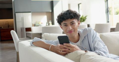 Young Man Relaxing with Smartphone in Modern Living Room