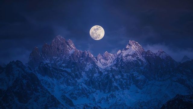 Full Moon Illuminating Snow-Covered Mountain Peaks