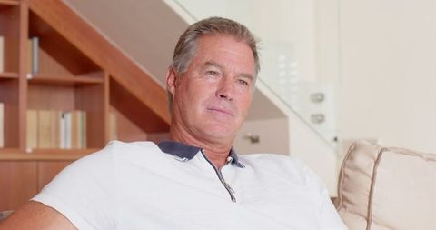 Middle-aged Man Relaxing on Sofa in Modern Home Interior