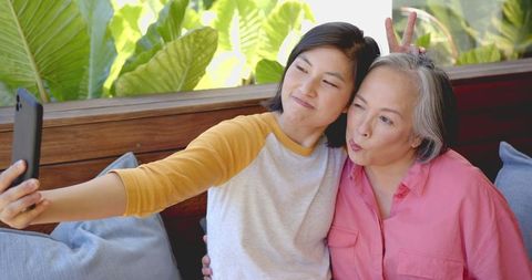 Two Women Making Funny Faces Taking Selfie Bonding