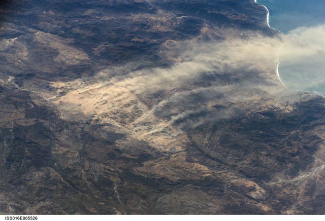Photo shows dust plumes generated by Santa Ana winds over Baja California, Mexico. This view is taken from the International Space Station and highlights the dry environmental impact and geographical features around Real del Castillo Valley. Useful for illustrating climate phenomena, weather impact studies, and geographical landscapes in educational materials, documentaries, and environmental research.