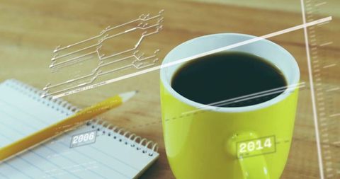 Yellow coffee mug sitting on wooden desk with notebook and pencil, minimalist workspace