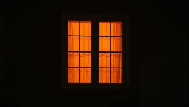 Orange-hued window frame shining at night