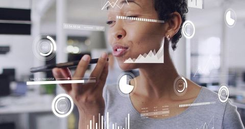 Professional woman speaking into smartphone using augmented reality analytics in office