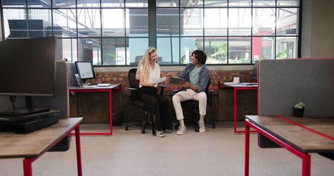 Two Colleagues Collaborating in Modern Office Using Tablet Technology