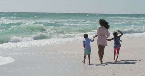 Family Enjoying Walk Along Seashore in Sunlight - Download Free Stock Images Pikwizard.com