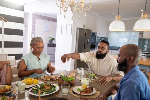 Family Gathered around Dining Table Sharing Meal at Home
