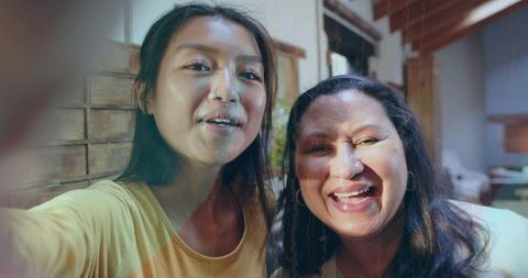 Mother and Daughter Taking Selfie at Home Leaning Close Smiling in Cozy Living Room