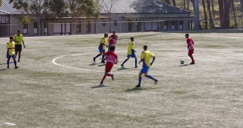 Youth soccer players warm up on sunny field in vibrant uniforms