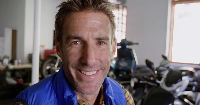 Smiling Middle-aged Man in Motorcycle Workshop - Download Free Stock Images Pikwizard.com