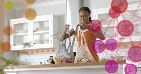 Smiling woman organizing fresh produce in mesh bags in modern kitchen