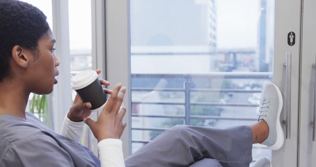 Young Nurse Relaxing with Coffee Near Window - Download Free Stock Images Pikwizard.com