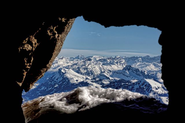 Scenic Snow-Capped Mountains Framed by Rocky Cave Opening - Download Free Stock Photos Pikwizard.com