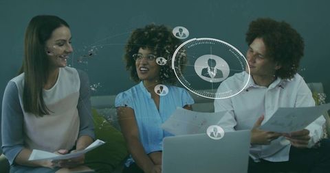 Team collaborating over laptop and documents with digital HUD network interface