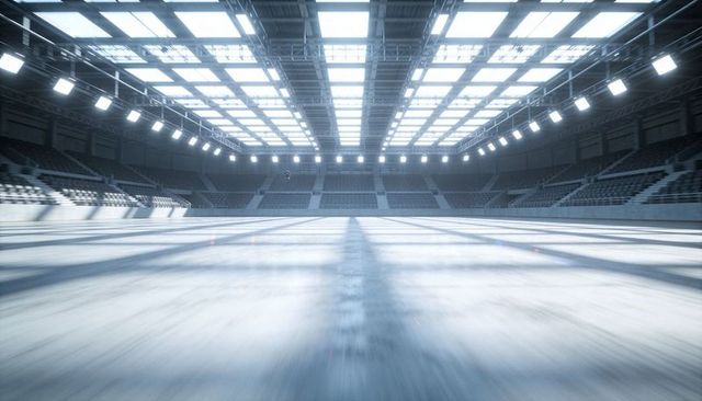 Empty modern indoor arena with reflective floor and dramatic skylight grid lighting