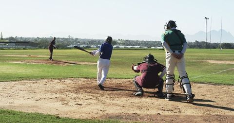 Baseball game action with pitcher, batter, and umpire on field