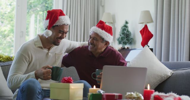 Happy father and son in santa hats embracing while having coffee during laptop christmas image call - Download Free Stock Photos Pikwizard.com