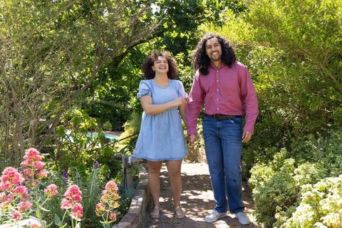 Couple strolling hand in hand through lush garden