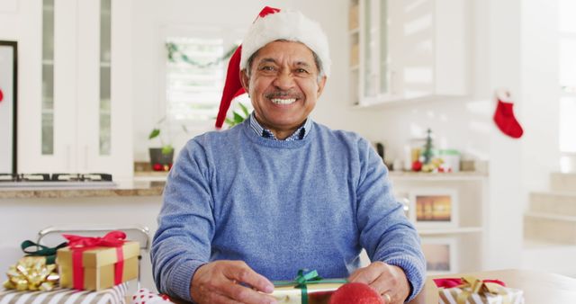 Senior Man Wrapping Christmas Presents in Kitchen - Download Free Stock Images Pikwizard.com