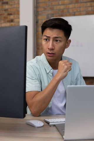 Motivated asian professional achieving goals at modern workspace