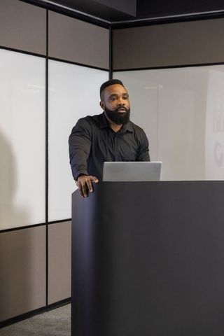 Professional Speaker Presenting with Laptop at Modern Event