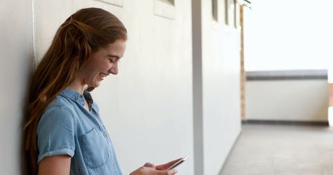 Young Woman Smiling at Smartphone Indoors with Copy Space - Download Free Stock Images Pikwizard.com