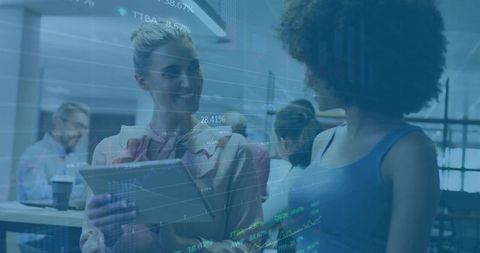 Two Women Collaborating in Modern Office with Tablet and Coffee