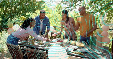 Friends Serving Cake at Backyard Patio Party with Balloons on Sunlit Deck